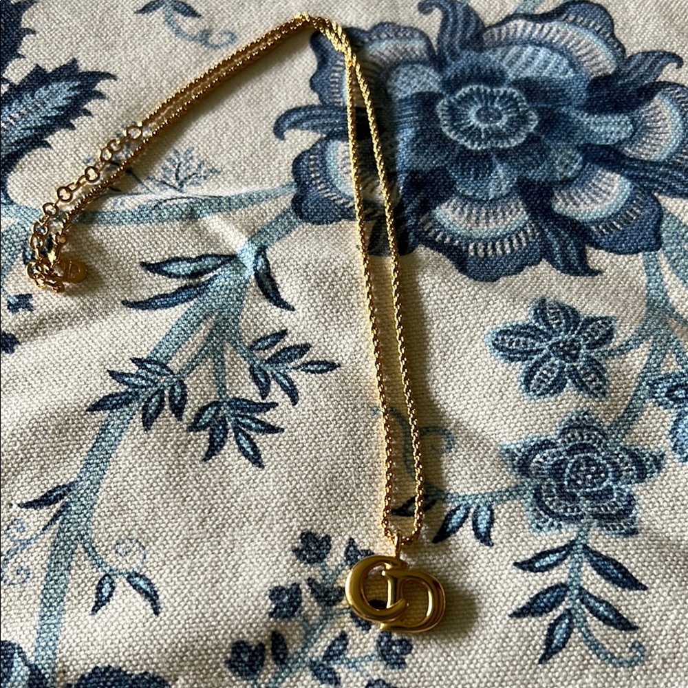 Christian Dior 18K electroplated gold logo pendant.